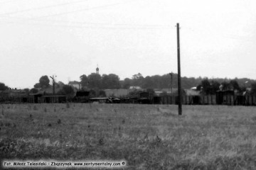 Lwówek w lipcu 1985 roku. Po przeciwnej stronie ulicy koło dworca kolejki widok fragmentu linii wąskotorowej do Komorowa nie czynnej od 1963 roku.